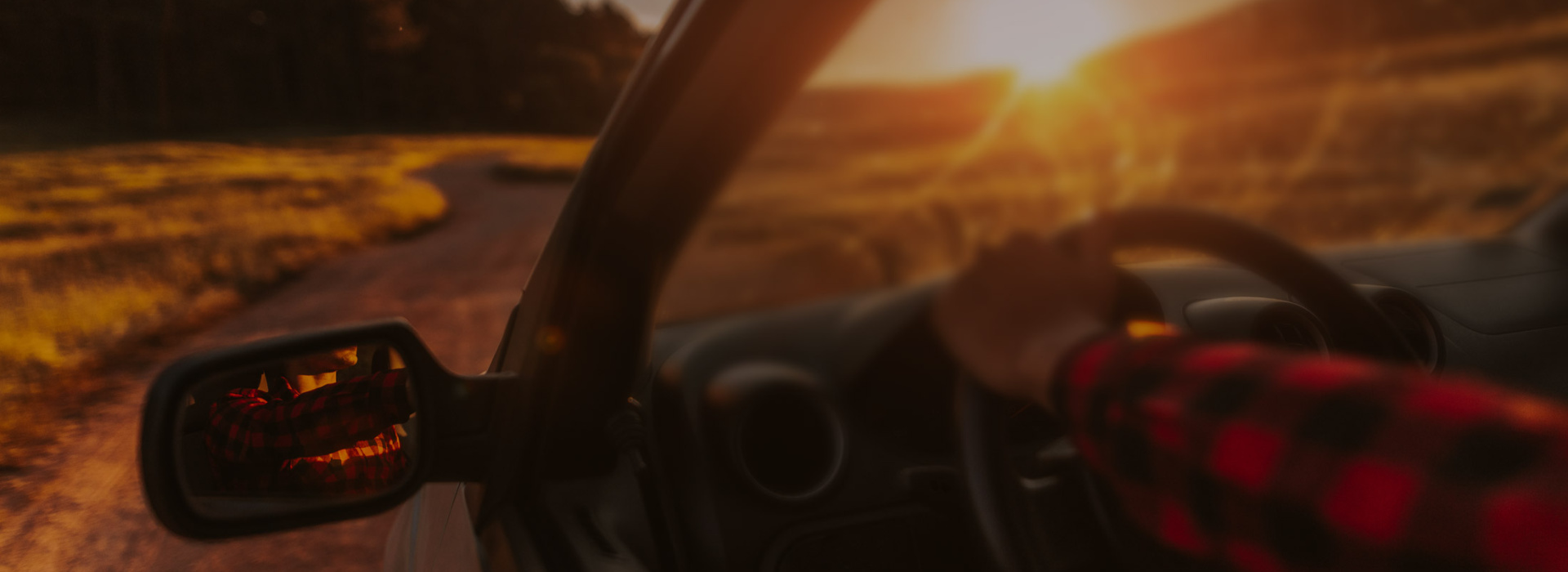 man driving during sunset